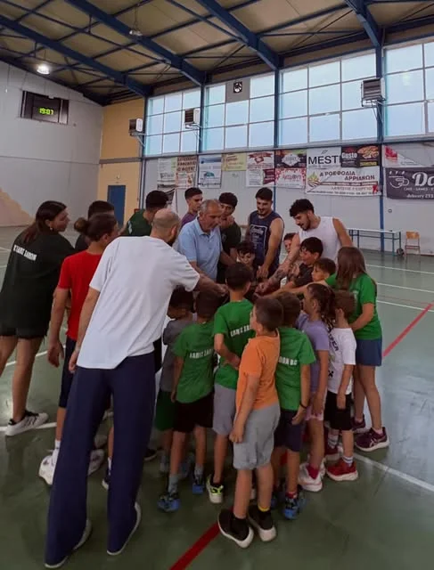 Παιδιά της ακαδημίας της Ελπίδας σε ομαδικό κύκλο στο γήπεδο